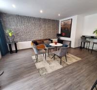 Nappali székekkel és kanapéval egy családi házban, dekoratív fal és bár sarok.