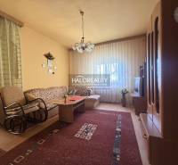 Nappali egy családi házban kényelmes kanapéval és fa dekorációjú padlóval.