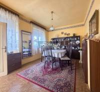 Ebédlő egy családi házban, fa dekorációjú padlóval, díszített szőnyeggel és asztallal.