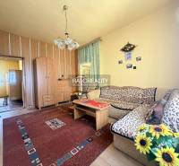 Nappali egy családi házban, fa dekorációjú padlóval és virágokkal.