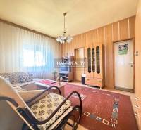 Nappali családi házban ablakkal, fa dekorációjú falakkal és bútorokkal.