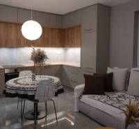 Konyha egy kétszobás lakásban fa dekor padlóval és kerek asztallal.