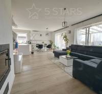 Nappali egy családi házban nagy kanapéval és fa dekorációjú padlóval.