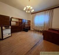 Nappali egy családi házban fa dekorációval, függönyökkel és kanapéval.