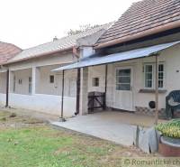 Régi házikó Mužlában terasszal és fa tetővel.