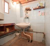 Fürdőszoba mosdóval, polcokkal és világítással, alkalmas rekreációs telkekre.