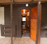 Bejárat a faházzal nyitható ajtóval és verandával az Üdülőtelek területén.