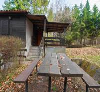 Nyaraló terasszal és asztallal a Holčíkovce-i üdülőterületen, erdővel körülvéve.