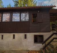 Faház a holčíkovcei üdülőterületen, zölddel és fákkal körülvéve.