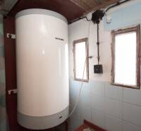 Bojler a kék csempékkel burkolt belső térben, üdülőterületen.