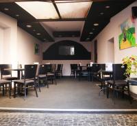 Belső vendéglátó terek ülőhelyekkel, dekorációkkal és szobanövénnyel.