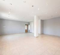 Kereskedelmi helyiségek fehér falakkal, kerámia padlóval és pontvilágítással.