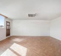 Tágas üzlethelyiség nagy ablakkal és fa dekorációjú padlóval.