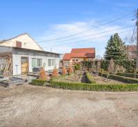 Üzlethelyiség Okočban, kerttel, fákkal és bokrokkal körülvéve.