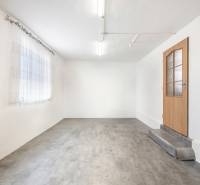 Fehér falak, beton padló, faajtó és függöny az üzlethelyiségben.