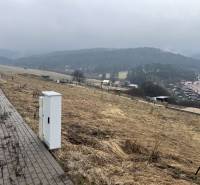 Lakóterületek Ólublón, kilátással a friss zöld dombokra.