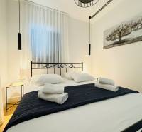 Hangulatos hálószoba egy villában fekete fém ágykerettel és függő lámpákkal.