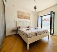 Világos hálószoba villában, ággyal, erkéllyel és fa dekorációjú padlóval.