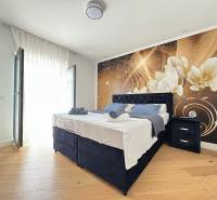 Hálószoba egy villában dekoratív fallal és fa dekorációjú padlóval.