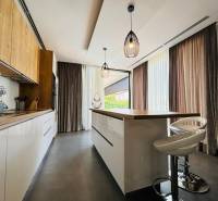 A villa konyhai része stílusos világítással és fa dekorációjú padlóval.