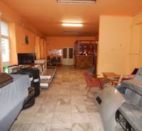 Vendéglátóipari helyiségek belső tere narancssárga falakkal, raktárhelyiség székekkel és felszereléssel.