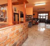 Étkező belső tér asztallal és könyvespolcokkal.