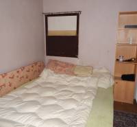 Szoba ággyal, polccal és radiátorral, vendéglátóipari helyiségek felújítására alkalmas.