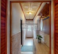 Folyosó egy családi házban fa burkolatokkal és dekoratív mennyezettel.