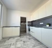 Konyha a kétszobás lakásban fa dekor padlóval és világos bútorokkal.