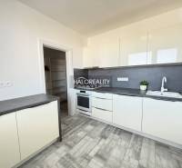 Konyha egy kétszobás lakásban fehér bútorokkal és fa dekoros padlóval.