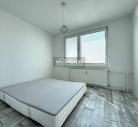 Hálószoba szürke, fa mintázatú padlóval egy kétszobás lakásban.