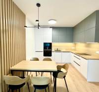 Konyha egy kétszobás lakásban fa dekoros padlóval és étkezőasztallal.