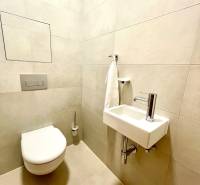 Fürdőszoba egy kétszobás lakásban WC-vel, mosdóval és világos csempékkel.