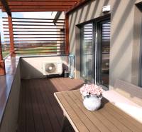 Kétszobás lakás terasza kilátással a környékre és virágdíszítéssel.