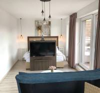 Nappali egy kétszobás lakásban fa dekor padlóval és külön hálószobás zónával.