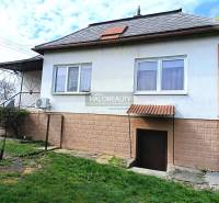 Családi ház Hráňban füves udvarral, ablakokkal és bejárati ajtóval.