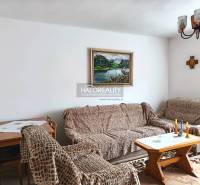 Nappali egy családi házban kanapékkal és egy képpel a falon.