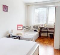 Hálószoba egy négy szobás lakásban ággyal, asztallal és fa dekorációjú padlóval.