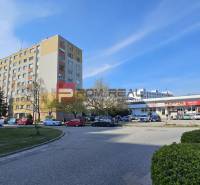 Lakóház és bevásárlóközpont a Pozsony V. kerületében található Žehrianska utcában, parkolóval és autókkal.