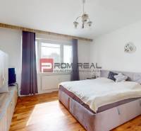 Hálószoba egy 4 szobás lakásban kényelmes ággyal és fa dekorációjú padlóval.