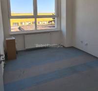 Prázd iroda nagy ablakkal, fehér falakkal és fa dekorációjú padlóval.