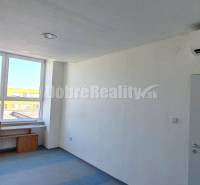 Iroda belső tér fehér falakkal, kék padlóval és nagy ablakkal.