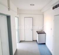 Irodák mosdóval és ajtókkal, fa dekorációjú padló, fehér falak.