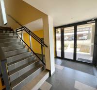 Lépcsőház sötét csempékkel és üvegezett ajtókkal Kassán, a Borievkova utcában.