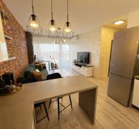 Nappali bárpulttal, fa hatású padlóval és téglás akcentussal.