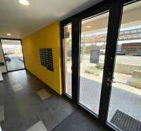 Bejárati folyosó postaládákkal és üvegezett ajtókkal egy kétszobás lakásban.