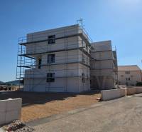 Építési projekt Srima városában, állványokkal körülvéve és tengerparti környezetben.