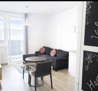 Nappali egy kétszobás lakásban fa dekor padlóval és erkéllyel.