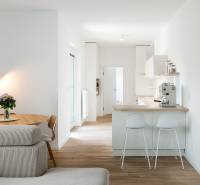 Konyha asztallal, kanapéval és fa dekorációjú padlóval egy 4 szobás lakásban.