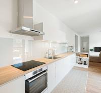 Konyha egy 4 szobás lakásban, fa dekoros padlóval és világos berendezéssel.